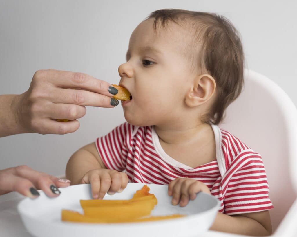 adorable baby playing with food